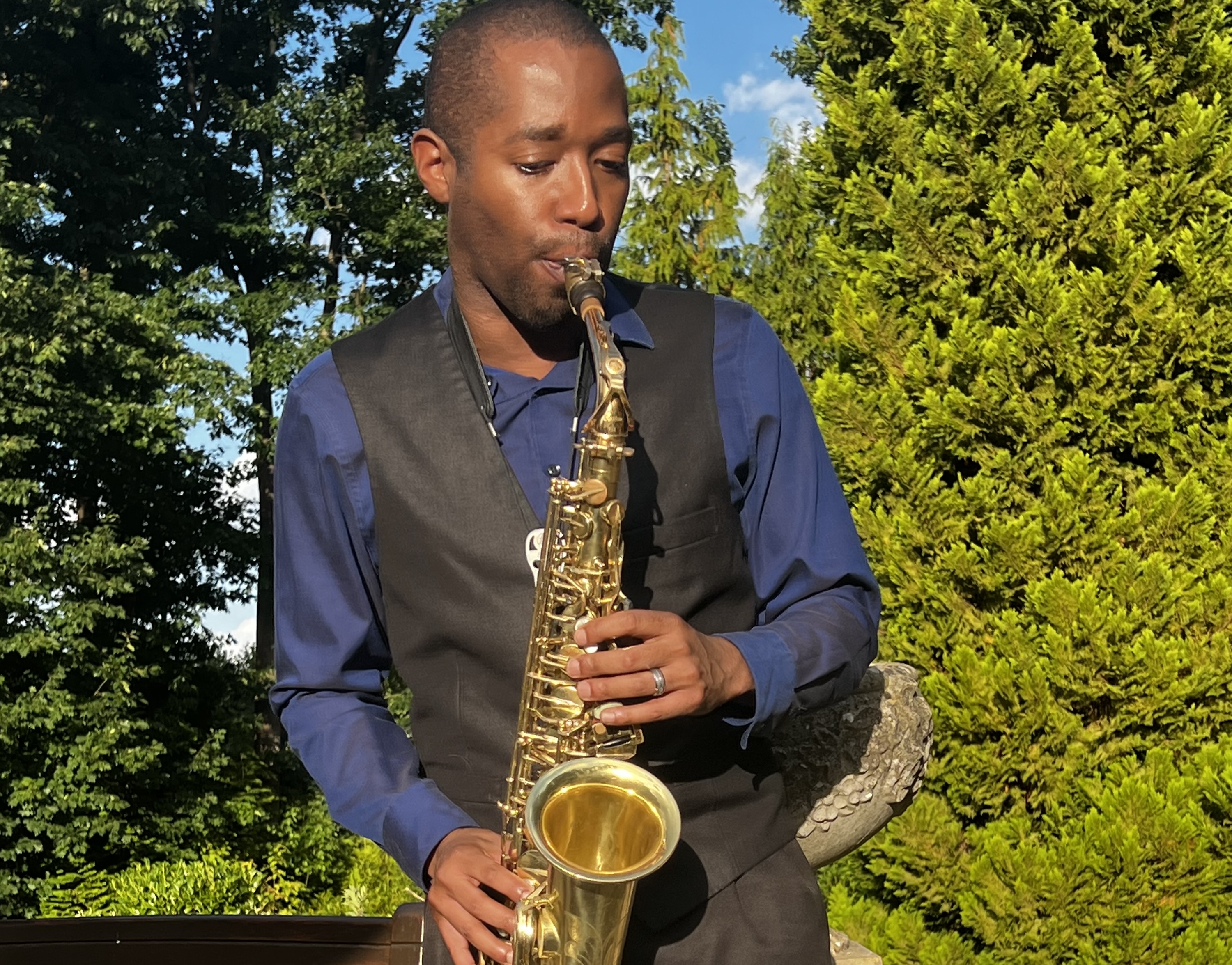 Devin playing saxophone at an outdoor wedding reception
